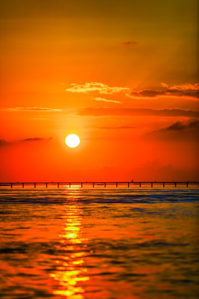 Mesmerizing sunset casting vibrant hues over a tranquil ocean horizon.