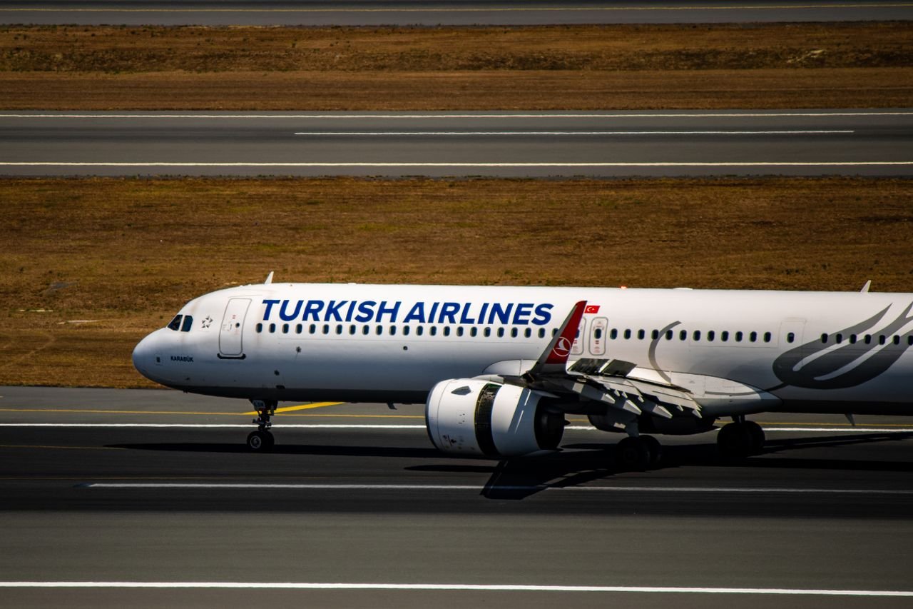 Turkish Airlines Airbus A320 taxiing at Istanbul's runway on a clear day.
